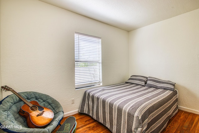 bedroom featuring hardwood / wood-style flooring and baseboards