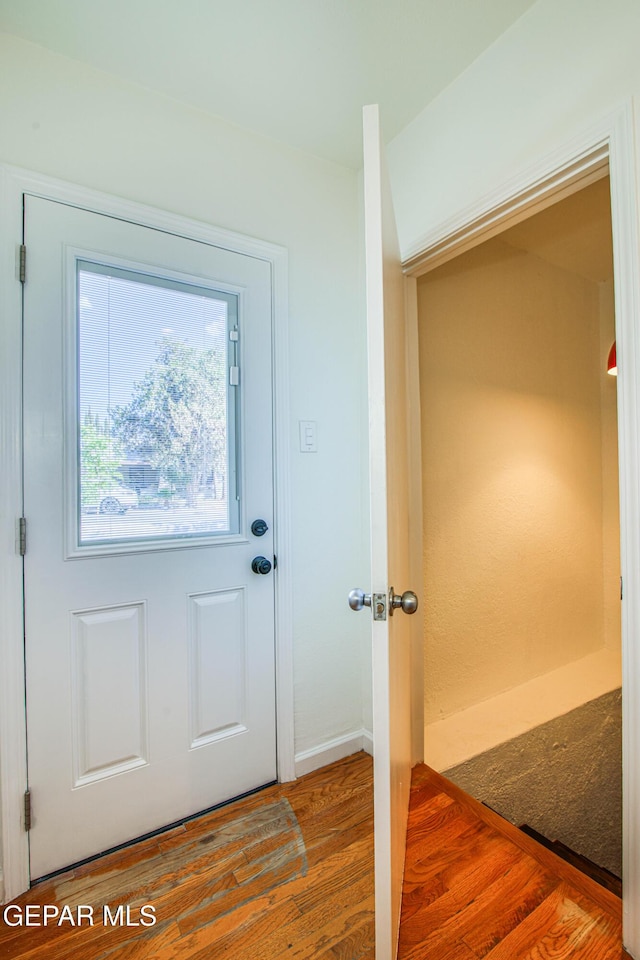 doorway to outside featuring wood finished floors and baseboards
