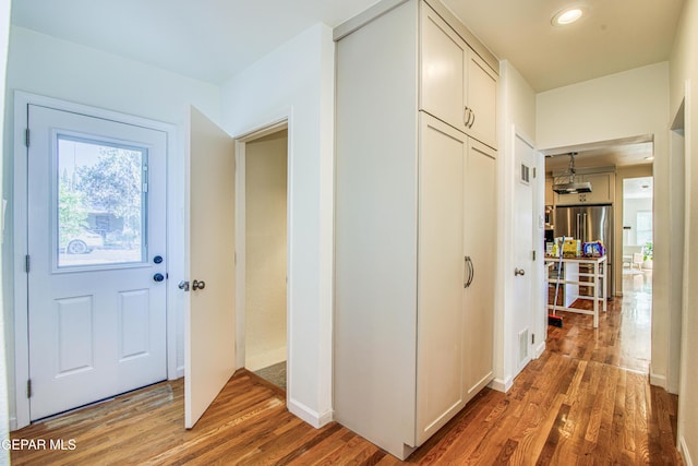 hall with light wood-style floors and recessed lighting