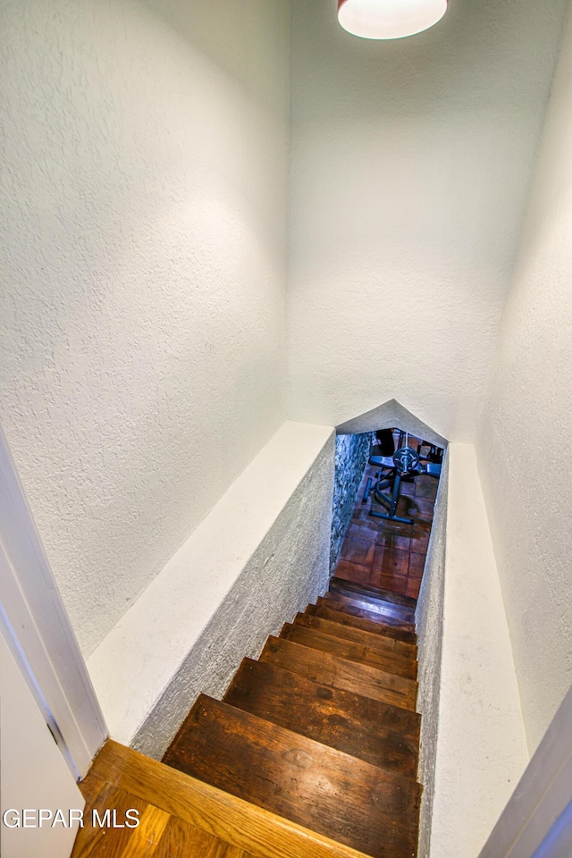 staircase featuring a textured wall
