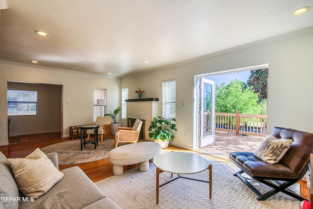 living room with ornamental molding, wood finished floors, recessed lighting, and baseboards