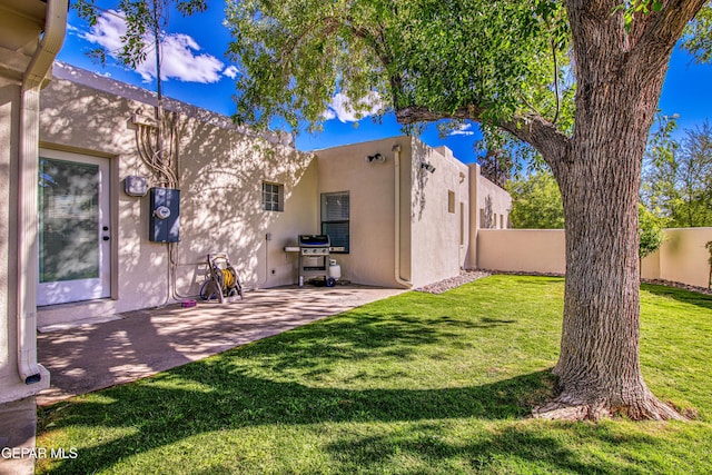 rear view of property featuring stucco siding and a patio