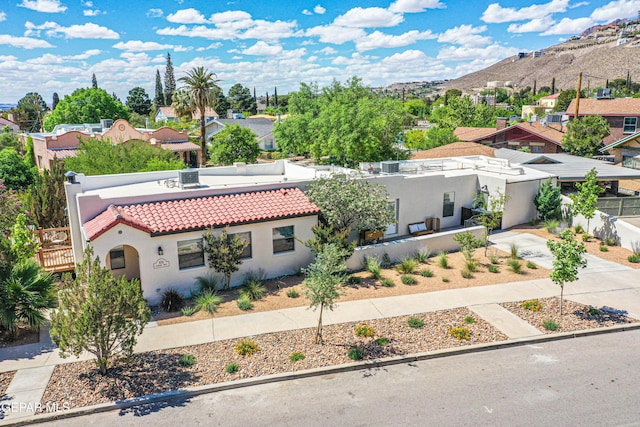 mediterranean / spanish-style house with stucco siding, a tiled roof, a mountain view, and a residential view