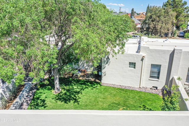 view of property exterior featuring stucco siding and a lawn