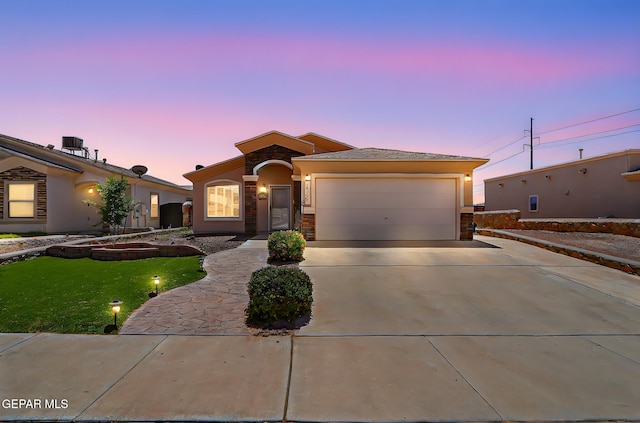 14182 John Scagno, El Paso, TX 79938 - mediterranean / spanish house featuring stone siding, stucco siding, driveway, and a garage
