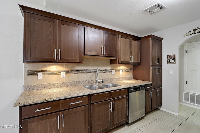 14182 John Scagno, El Paso, TX 79938 - kitchen featuring stainless steel dishwasher, visible vents, a sink, dark brown cabinetry, and decorative backsplash