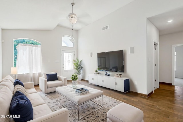 living room with baseboards, high vaulted ceiling, visible vents, and wood finished floors