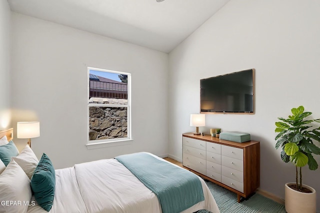 bedroom featuring baseboards and vaulted ceiling