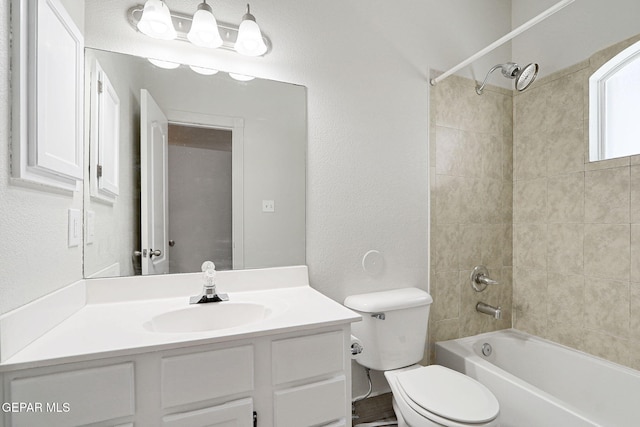 full bath with vanity, toilet, washtub / shower combination, and a textured wall