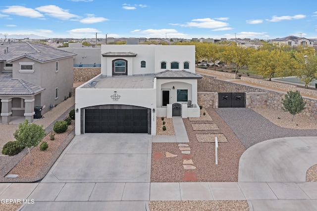 view of front of home with concrete driveway, a gate, stucco siding, an attached garage, and a residential view