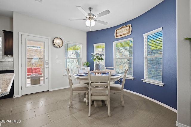 dining area with ceiling fan, baseboards, and light tile patterned flooring