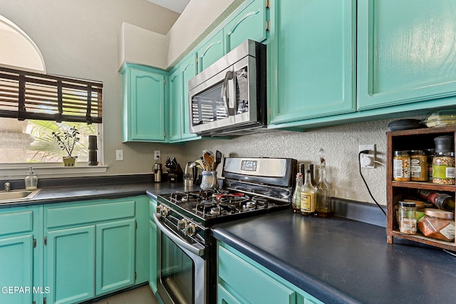 kitchen with dark countertops, stainless steel appliances, and a sink