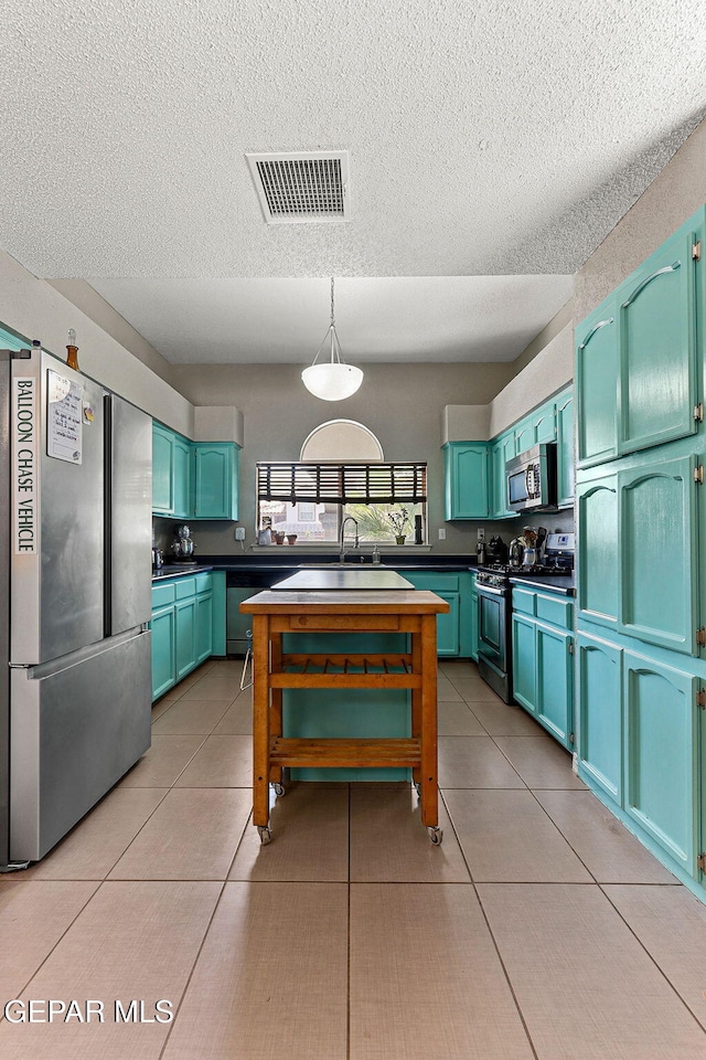 kitchen featuring light tile patterned floors, visible vents, appliances with stainless steel finishes, and a textured ceiling