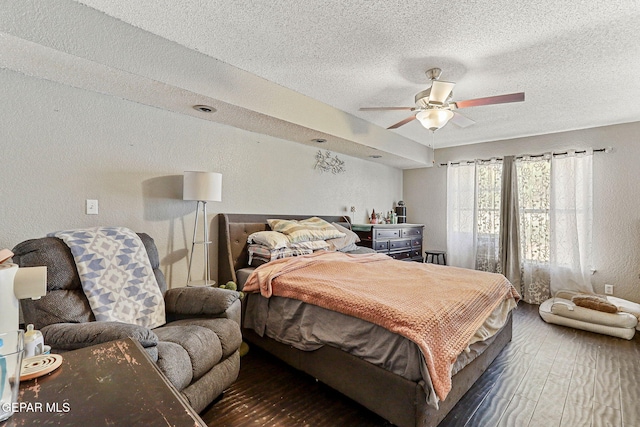 bedroom with a textured ceiling, ceiling fan, and a textured wall