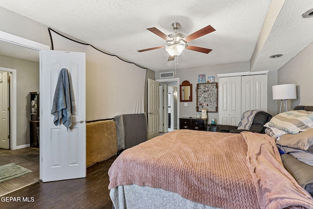 bedroom with dark wood-type flooring, a textured ceiling, a closet, and ceiling fan
