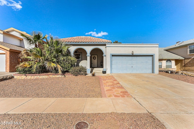 mediterranean / spanish house featuring covered porch, a garage, a tiled roof, stucco siding, and driveway