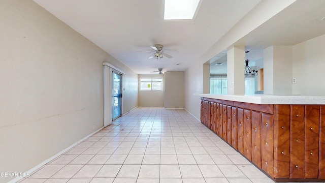 corridor featuring light tile patterned floors and baseboards