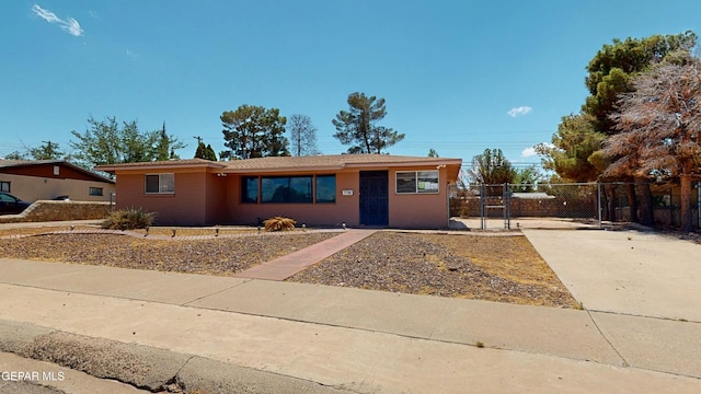 ranch-style home with a gate, driveway, and fence