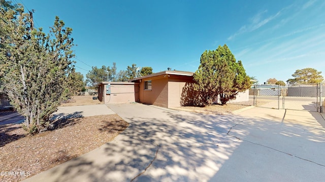 view of side of property with a gate, fence, and driveway