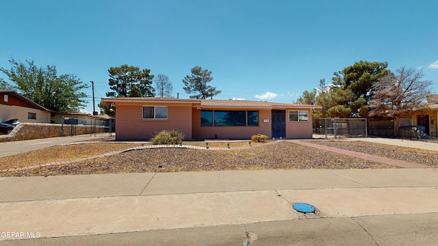ranch-style home featuring fence