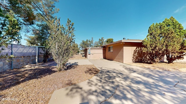 view of yard with fence and concrete driveway