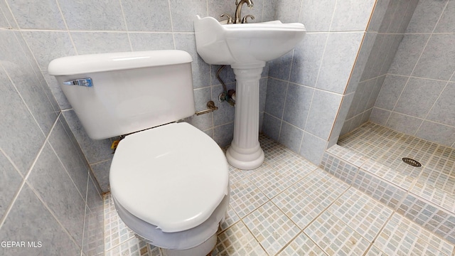 full bathroom featuring a stall shower, toilet, tile walls, and tile patterned floors