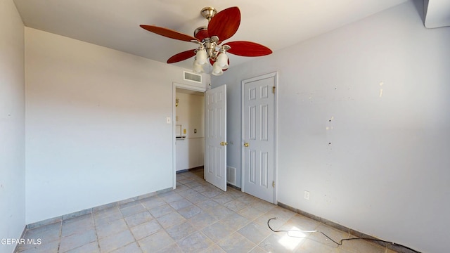 empty room featuring ceiling fan and baseboards