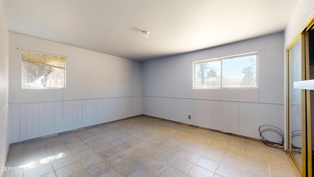 spare room featuring a wainscoted wall