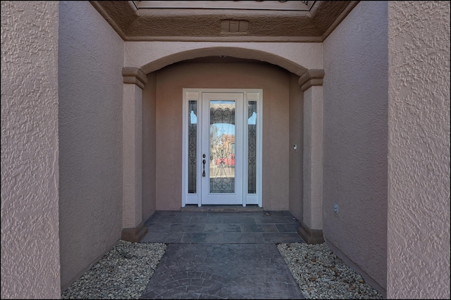 view of exterior entry featuring stucco siding