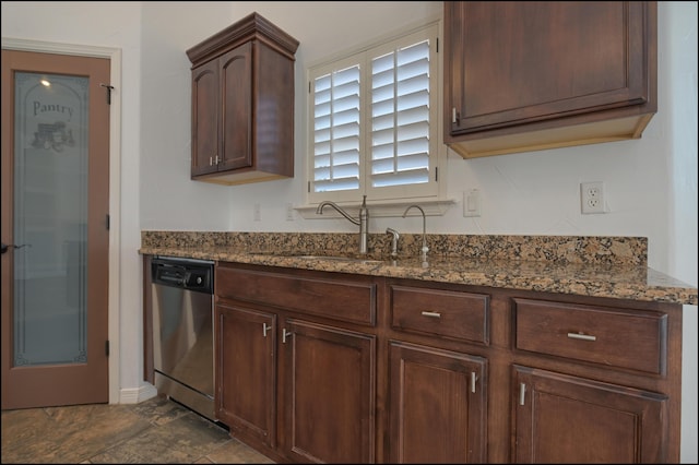 kitchen with dishwasher, a sink, dark stone countertops, and baseboards