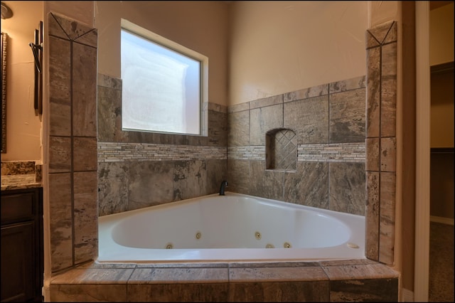 full bath featuring a tub with jets and vanity