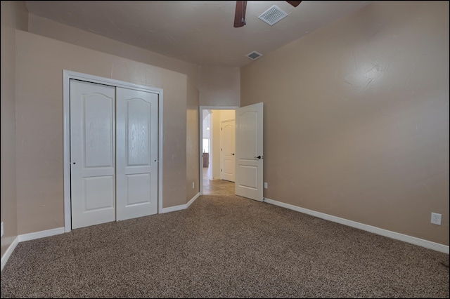 unfurnished bedroom with carpet flooring, a closet, baseboards, and a ceiling fan