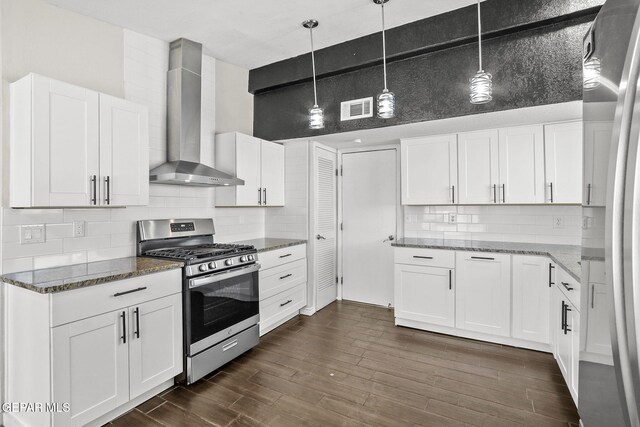 kitchen featuring gas stove, wall chimney exhaust hood, dark stone counters, and backsplash