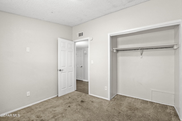 unfurnished bedroom featuring carpet floors, a closet, a textured ceiling, and baseboards