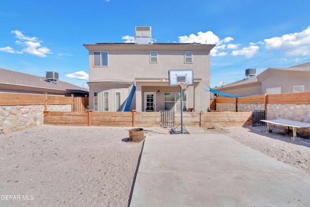 back of property with stucco siding, a fenced backyard, and central air condition unit