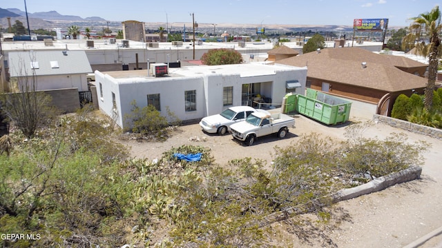 back of house with stucco siding and a mountain view