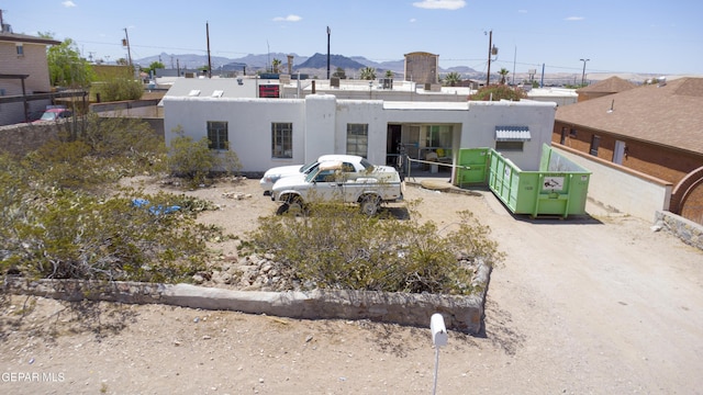 back of house with a mountain view and stucco siding