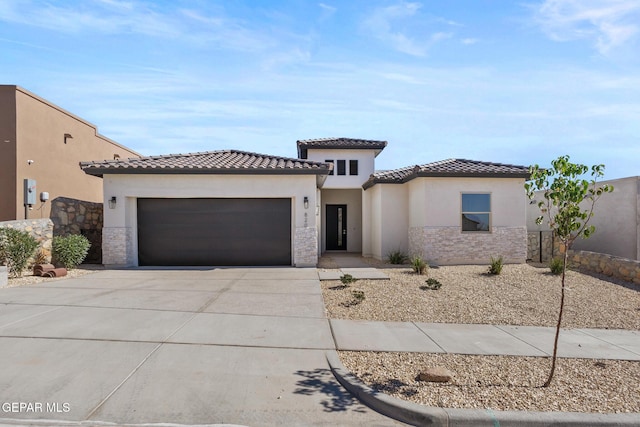 820 Acton St, Horizon City, TX 79928 - mediterranean / spanish-style house featuring a garage, concrete driveway, stone siding, a tile roof, and stucco siding