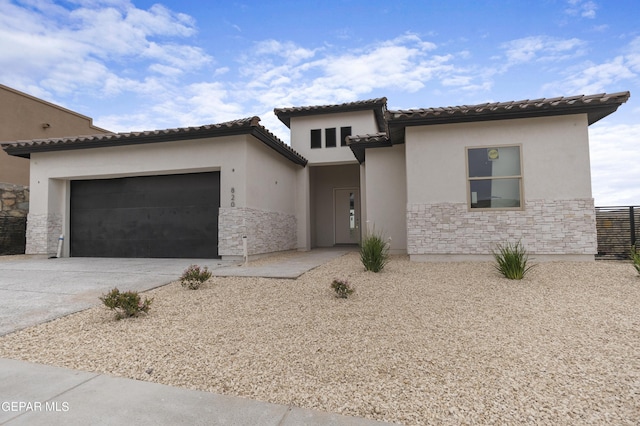 820 Acton St, Horizon City, TX 79928 - view of front of home featuring stone siding, driveway, a garage, and stucco siding