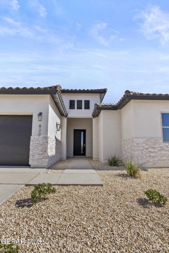 820 Acton St, Horizon City, TX 79928 - view of front of home with stone siding, stucco siding, and a garage