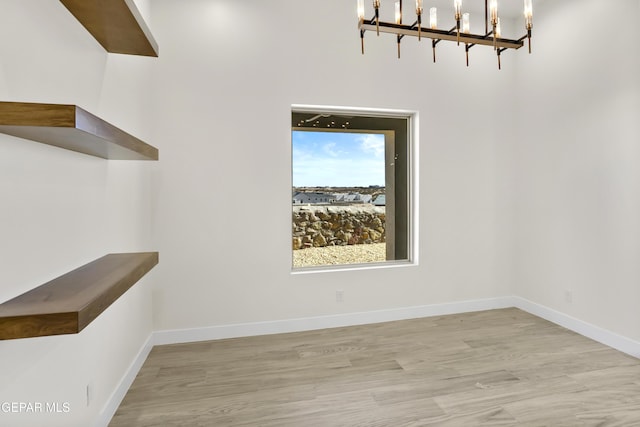 820 Acton St, Horizon City, TX 79928 - unfurnished dining area with a chandelier, baseboards, and wood finished floors