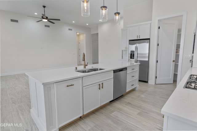 820 Acton St, Horizon City, TX 79928 - kitchen featuring appliances with stainless steel finishes, a sink, a ceiling fan, white cabinets, and light wood-style flooring