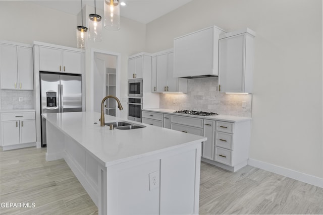 820 Acton St, Horizon City, TX 79928 - kitchen with stainless steel appliances, a sink, decorative backsplash, light countertops, and an island with sink