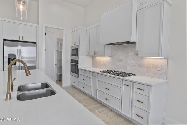 820 Acton St, Horizon City, TX 79928 - kitchen with appliances with stainless steel finishes, a sink, white cabinets, backsplash, and light countertops