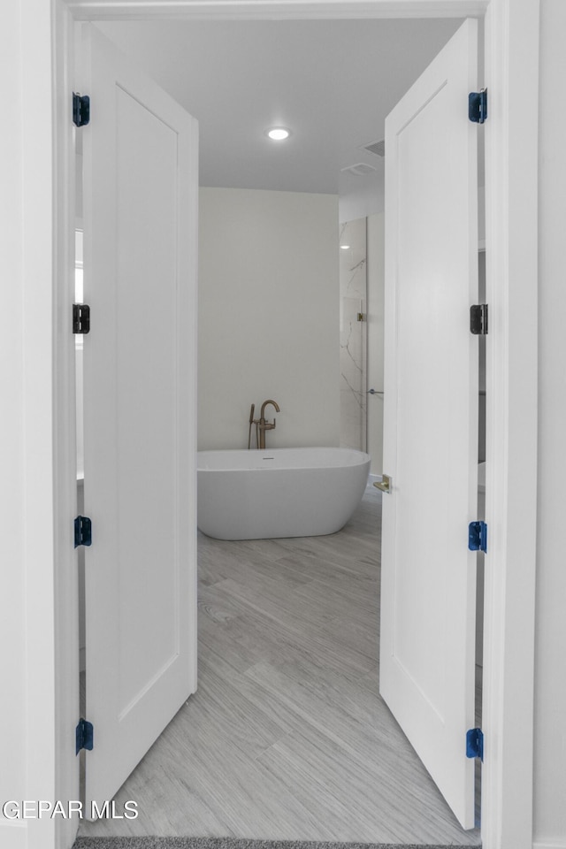 820 Acton St, Horizon City, TX 79928 - bathroom with a soaking tub, wood finished floors, and recessed lighting