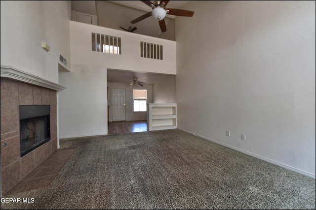 6205 Alina Baltazar Dr, El Paso, TX 79932 - unfurnished living room featuring a ceiling fan, carpet flooring, a high ceiling, and a fireplace