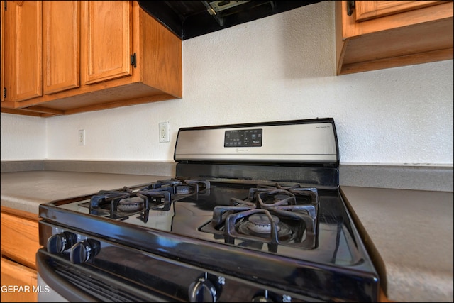 6205 Alina Baltazar Dr, El Paso, TX 79932 - kitchen view of gas stove, brown cabinets, and exhaust hood