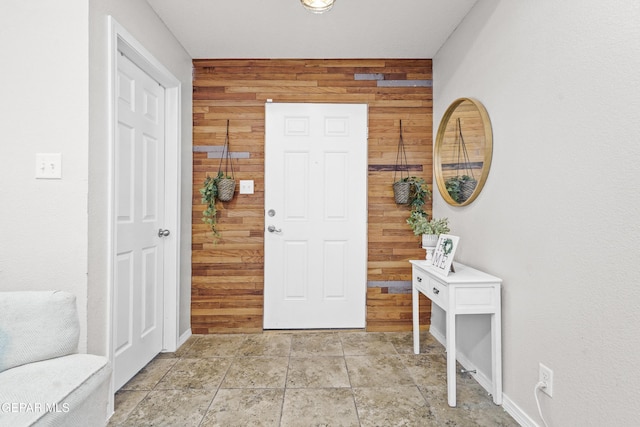 entryway featuring wooden walls and light stone finish flooring