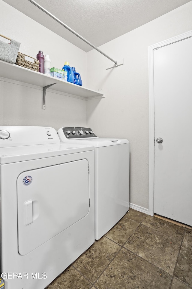 laundry room featuring washing machine and dryer and baseboards