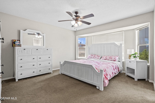 carpeted bedroom with a textured ceiling, baseboards, and ceiling fan